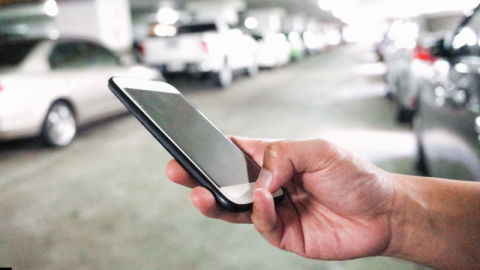 An arm is holding a phone. It can be concluded the person is calling a Lyft. 